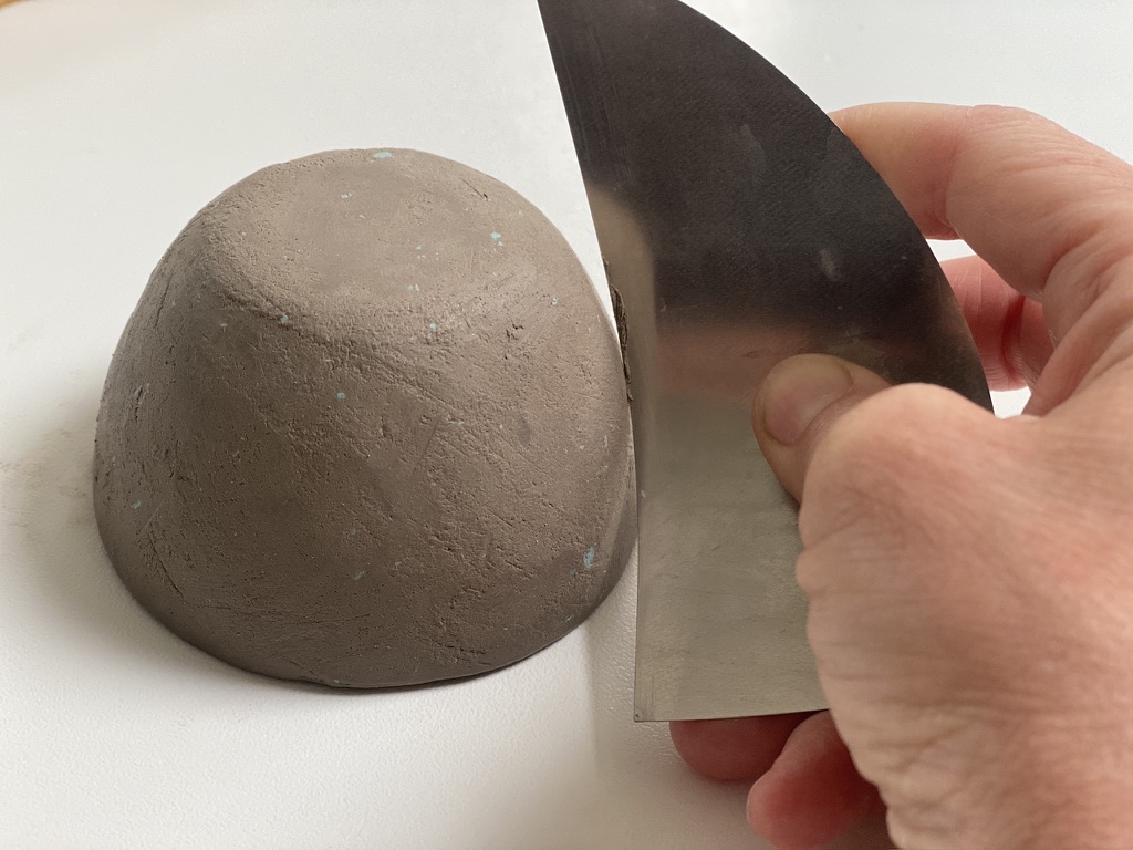 afgewerkte klei met ingemengde gekleurde chamotte zichtbaar in het oppervlak